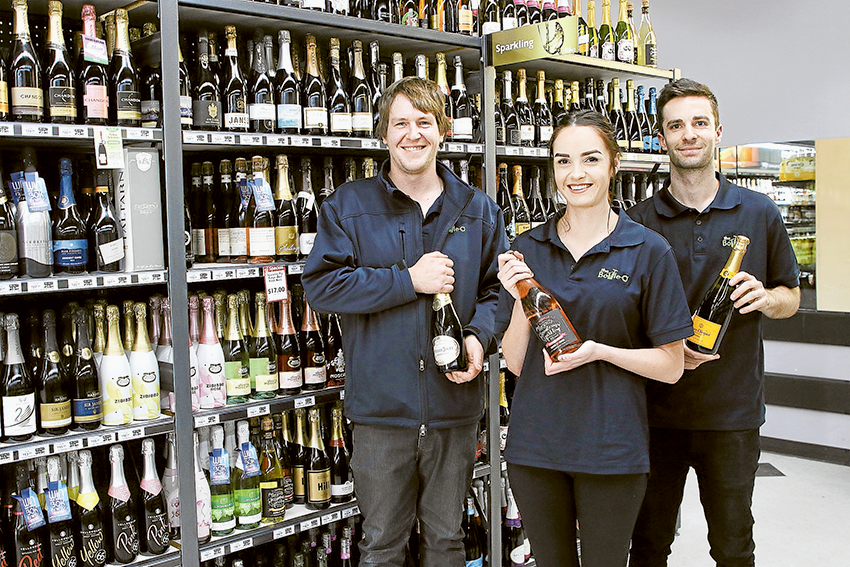 BOTTLE UP A BARGAIN… From left, Bottle-O Warehouse assistant manager, Hayden Bishop, store attendant, Sylvia Warrener and assistant manager, Jamie Spencer are each ready to deliver your party needs. Photo: David Lee.