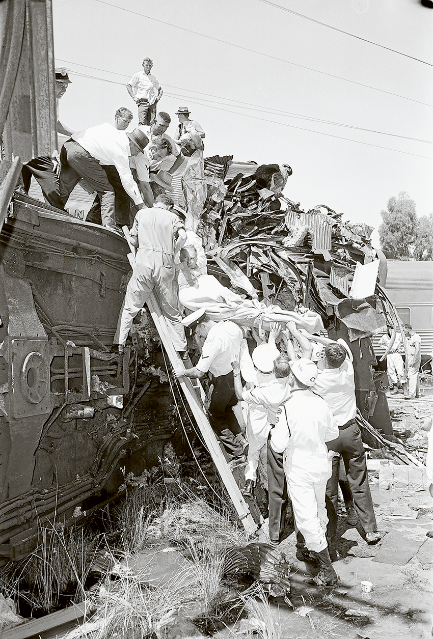 THOUSANDS GATHER TO REMEMBER… On February 7, 1969 the Southern Aurora overnight express service collided head-on with a freight train near Violet Town injuring 120 and killing nine people. Pictured in this photo is Paul Longhurst being carried out of the wreckage whose son and daughter attended the commemorations. Photo: State Library of Victoria.