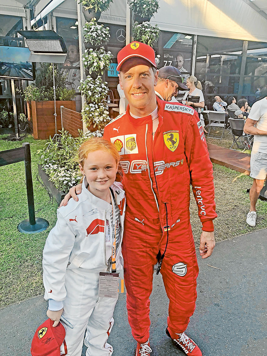 A DREAM COME TRUE… Local resident, Cedah Opie with Ferrari driver, Sebastian Vettel, who she was paired with at the Grand Prix for her Grid Kids experience recently. Photo: Supplied.