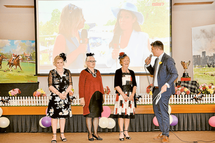 ED---Kensington-Gardens-Cup-Day ALL THE EXCITEMENT OF THE MELBOURNE CUP… From left, Kensington Gardens residents, Kaye Dobson, Judy Hanlon, Alice Morrison and emcee, Warwick Long at the special Melbourne Cup Day luncheon at Kensington Gardens last week. Photo: Supplied.