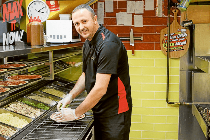 SERVE UP A SLICE WITH A SMILE… My Mates Pizza owner, Arlind Nebiu preparing one of My Mates’ delicious pizzas. Photo: David Lee.