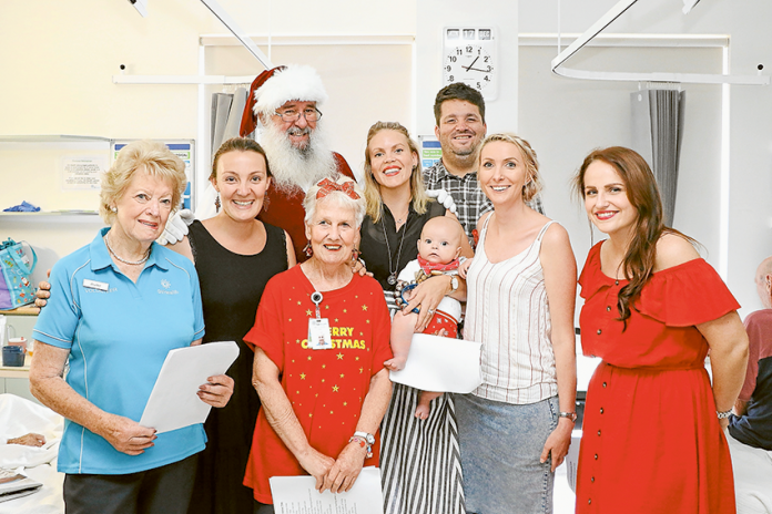 SPREADING CHRISTMAS CHEER THROUGH HOSPITAL HALLWAYS… From left, GV Health volunteer, Heather Halsall, Fortessima vocalist, Jamie-Lea, the big man himself, Santa Claus, GV Health volunteer, Faye Todd, Fortessima vocalist, Sophie Fimmel with baby Fletcher, Fortessima guitarist, Gabe Chowanetz, Fortessima vocalists, Emma-Jane and Kirsty Berry. Photo: Katelyn Morse.