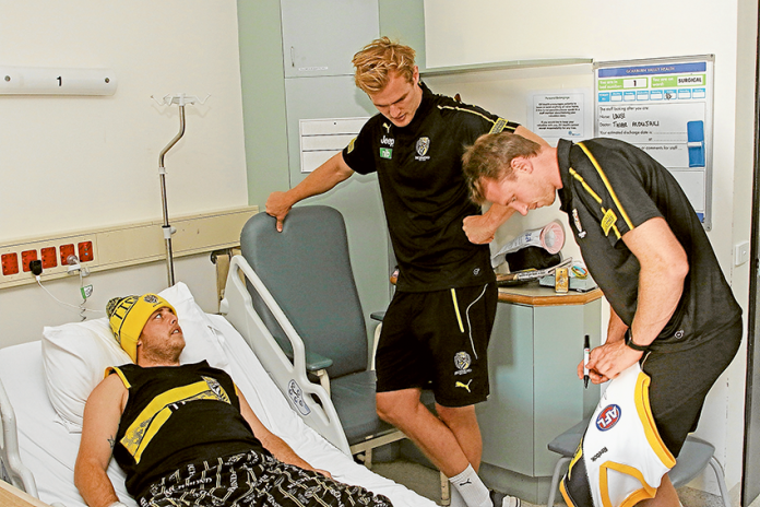SPECIAL VISIT TO GV HEALTH… From left, patient and mad Richmond Football Club supporter, Josef Bela with players, David Astbury and Dylan Grimes. Photo: David Lee.