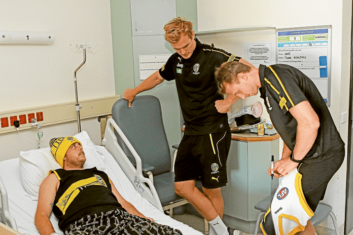 ED---GV-Health-Richmond-visit SPECIAL VISIT TO GV HEALTH… From left, patient and mad Richmond Football Club supporter, Josef Bela with players, David Astbury and Dylan Grimes. Photo: David Lee.