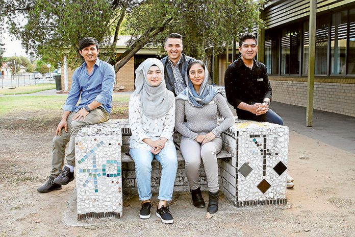 FP1---SELC-students-return-to-teach GIVING BACK TO THE COMMUNITY… From left, Shepparton English Language Centre multicultural education aids, Mustafa Rohani, Mariyam Jumakhan, Reza Kareen, Muzhgan Qazikhil and Ramzan Khair Ali have each returned to the centre to help other new arrivals. Photo: David Lee.