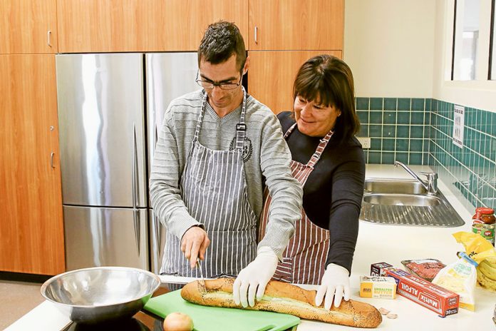 LENDING A HELPING HAND… Pasquale Pellegrino getting a hand from Donna O’Sullivan with making a tasty snack. Photo: David Lee.