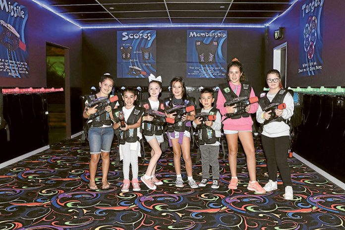 LOTS OF FUN WITH LASER TAG… From left, laser taggers are ready for an exciting friendly battle, Ella, Sienna, Charlotte, Zoe, Lucas, Mia and Molly. Photo: Ash Beks.