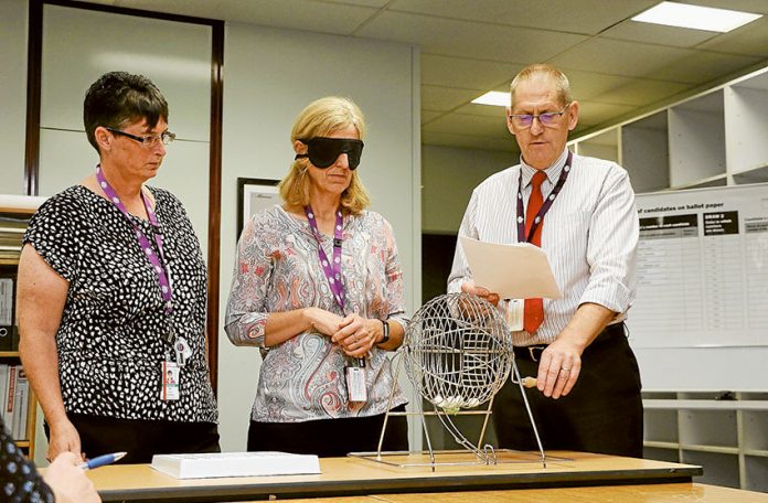 CANDIDATES LEARN POSITION OF NAMES… From left, Australian Electoral Commission (AEC) representatives, Jo Backway and Kay Tyers drawing the ballot positions with AEC returning officer for Nicholls, Craig Rickards supervising. Photo: Katelyn Morse.