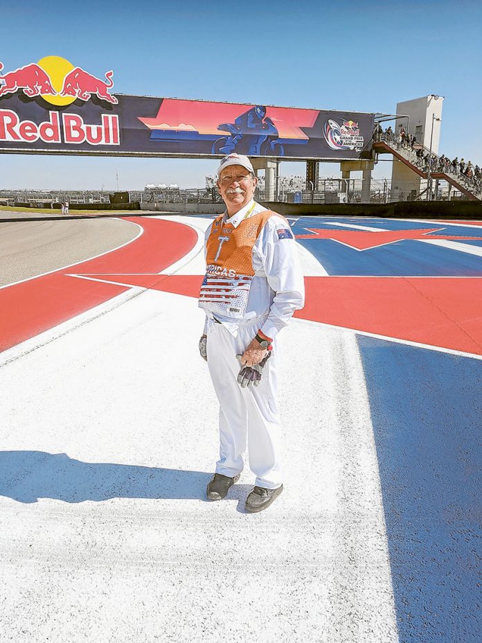 THE ROAR OF THE TRACK… Local resident, John Painter at turn 16 of the Circuit of the Americas, where he spent three days as a track marshal recently. Photo: Supplied.