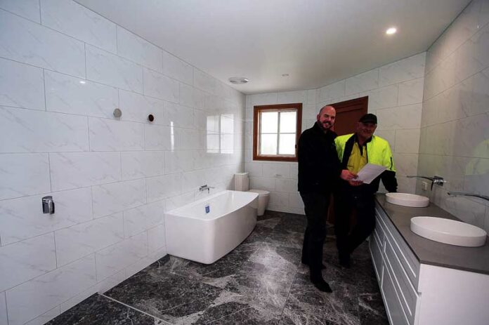 ANOTHER HAPPY RESIDENT... Link Building Systems director, Andy George showing client, John Dimitropoulos, his freshly renovated bathroom. Photo: Kelly Lucas.